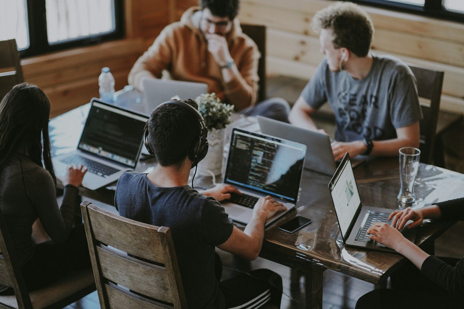 Equipo de desarrollo trabajando con portátiles en una mesa compartida